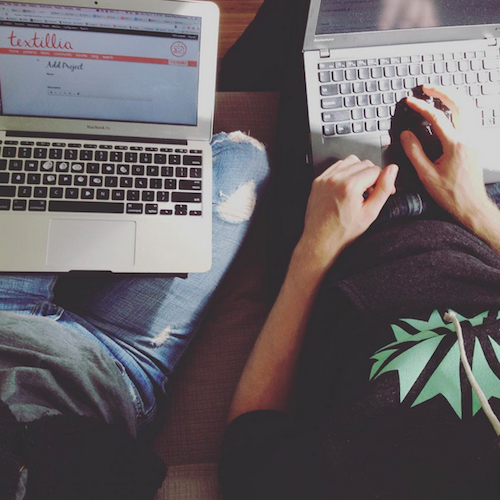 Downward shot of two people sitting with their laptops