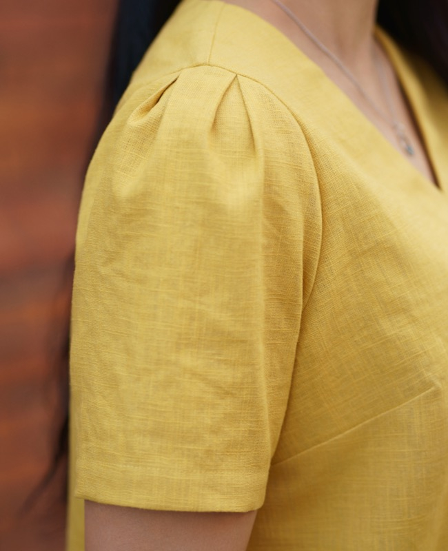Detail image of short sleeve, with pleats in sleave head