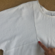 flat lay of garment with a hand pointing at the right corner of the sleeve seam