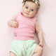 Baby wearing a pink shirt, green shorts and knotted headband