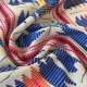 scrunched up fabric, a handwoven ikat in mostly blue and cream and red, with multicolored highlight areas