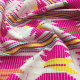 Scrunched pile of fabric, a handwoven ikat in pink, yellow, green, and white