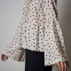 model shot of the top made in a white polka dot fabric, close-up of sleeve