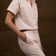 model shot of the coverall made in a light pink fabric, side view