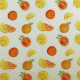 White fabric with a pattern of  yellow and orange citrus fruits