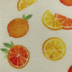White fabric with a pattern of  yellow and orange citrus fruits