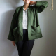 A person wearing a green jacket with big pockets