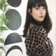 white woman with dark hair wearing a metallic polkadotted top with puffy elbow-length sleeves