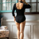 Back view of a woman in a black scoop back bodysuit.