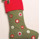 Green Christmas stocking with decorative red buttons