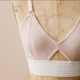 A pink and white bralette on a dress form.