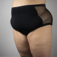 A person wearing black, super high rise undies with mesh side panels, viewed from side front