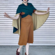 Woman wearing cape. The wrap front goes over her bust and crosses to tie at her back waist. The cape is thigh length and shows off the contrast interior.