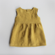 A yellow baby dress laid flat on a grey background. The dress has a plain, sleeveless bodice and a gathered skirt.
