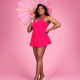 A black woman holding a pink and white parasol, wearing a bright pink, skirted swimsuit standing against a pink background.
