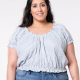 A woman models a blue and white striped, short raglan-sleeved top with elastic at the neckline, sleeves, and hem