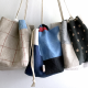 Three drawstring bags hanging against a white wall. The bags are a red checked linen, blue patchwork, and a linen and polkadot black patchwork.