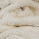offwhite sherpa fabric, scrunched up to show the texture