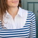 thin brunette woman wearing a striped long sleeved shirt with a white contrast yoke and collar