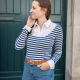 thin brunette woman wearing a striped long sleeved shirt with a white contrast yoke and collar