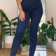 a slim woman wears tight dark blue jeans and a beige top