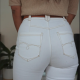 back view of a slim woman who wears tight flared white jeans and a beige top