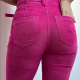 back view of a slim woman who wears tight hot pink corduroy jeans and matching pink top