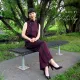 Woman sitting in a burgundy qipao jumpsuit