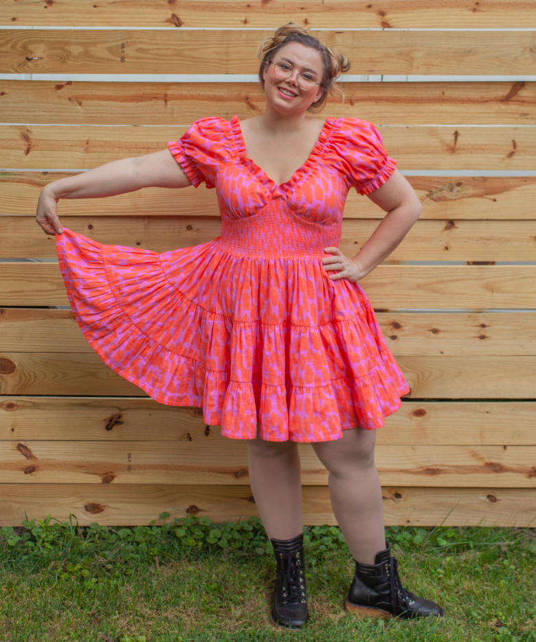 pink dress being held outwards at the skirt