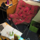 pink and brown store-bought butterfly chair in college, surrounded by books, technology, and knitting projects