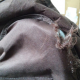 close-up of where old butterfly chair cushion fit over the frame - it is ripped, seams popped, in need of repair or replacement