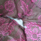 close-up of cushion of old pink and brown butterfly chair, showing rip in the seat, covered in cat fur